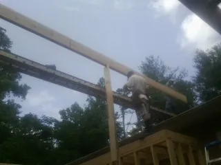Carpenter setting a ridge beam over a new addition frame — Ice Dam Removal by Roofing Brothers in Baring
