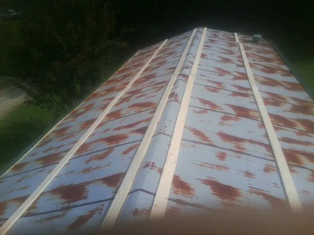 Rusted metal roof panels with new wood purlins before replacement — Storm Damage Roof Repair in Baring by Roofing Brothers