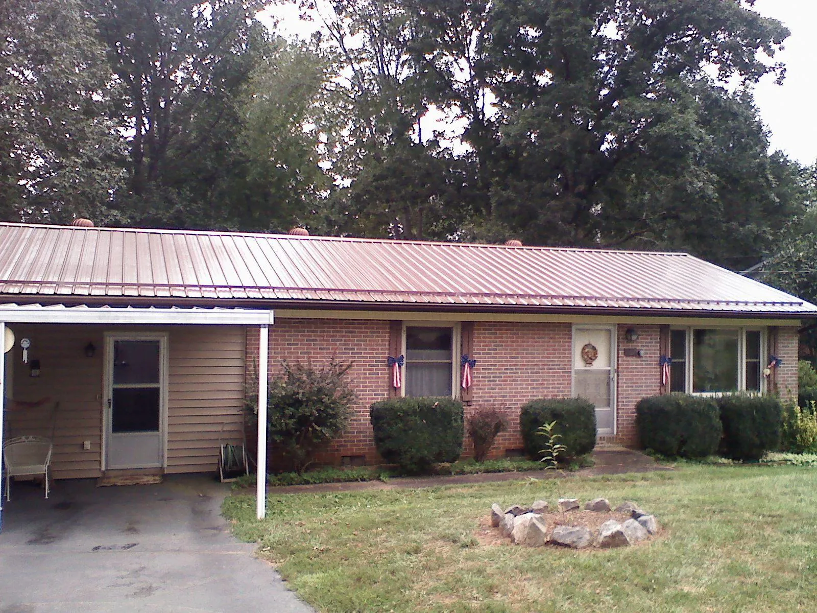 Bronze metal roof and carport on a brick ranch home — Roof Repair work by our crew in Baring