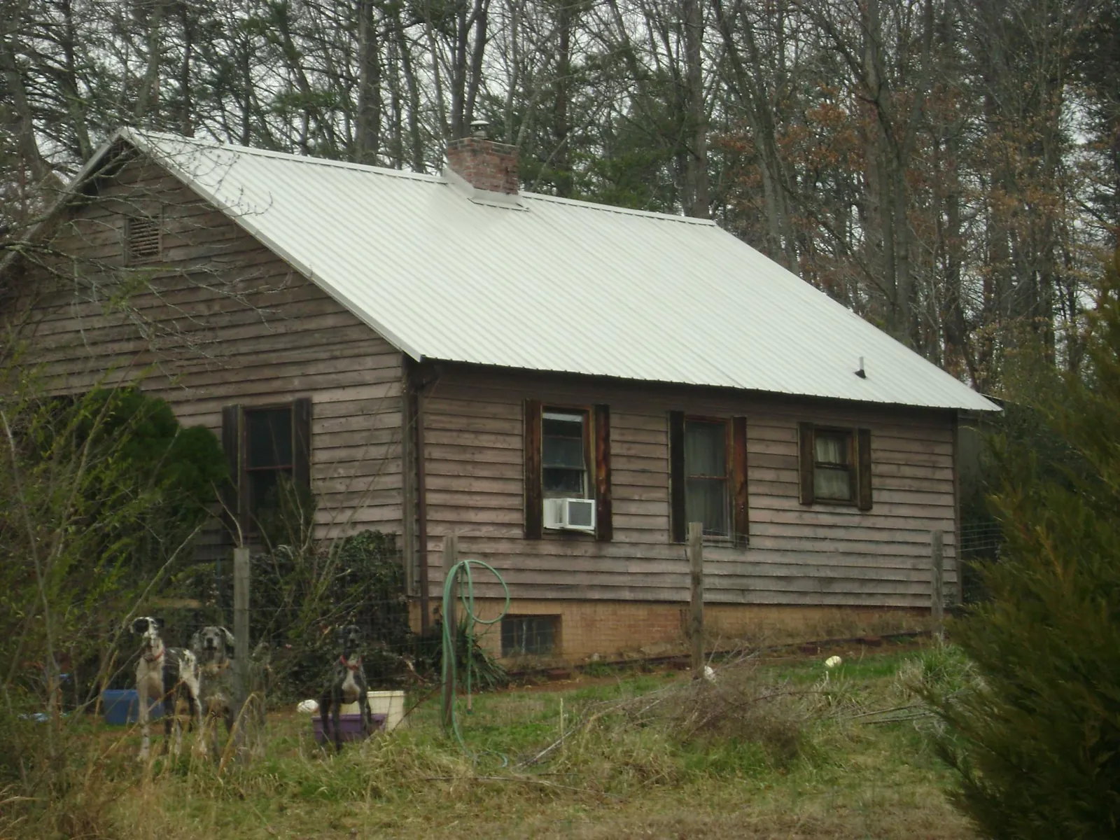 White metal roof on an old wood sided farmhouse, from a Metal Roof Installation job in Baring